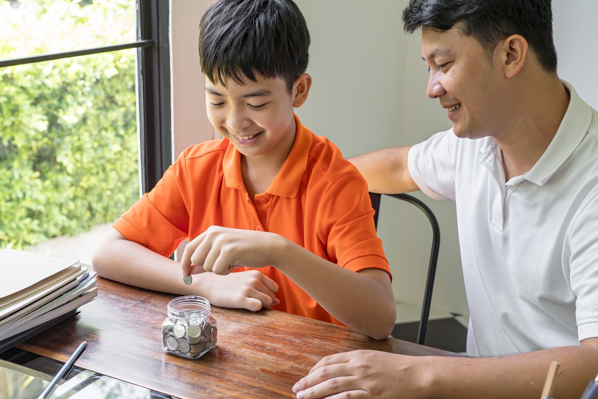 Asian father and son teaching son to Financial Literacy save mon